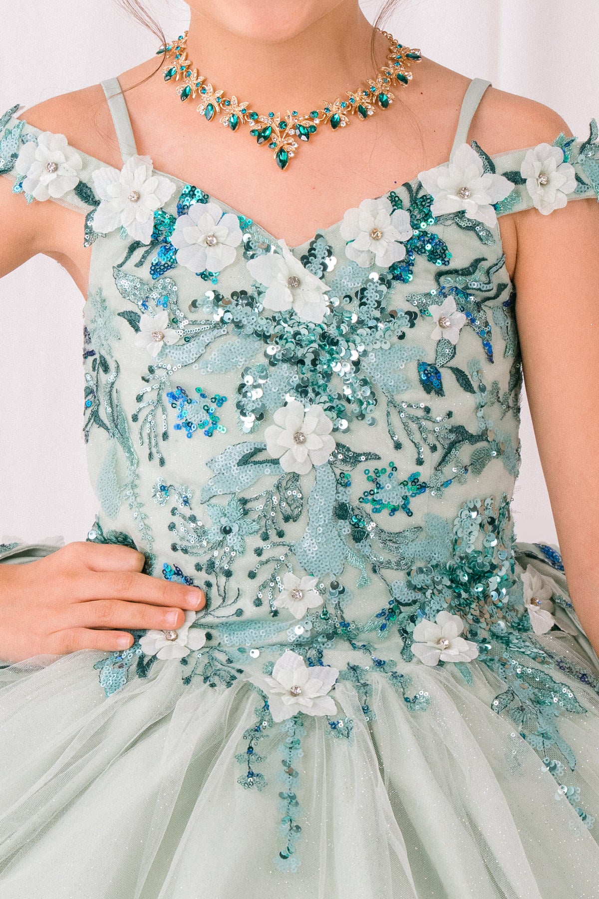 Sage fabric close-up kids mini quinceañera mini quince dress with floral lace, sequins and glitter tulle fabric.