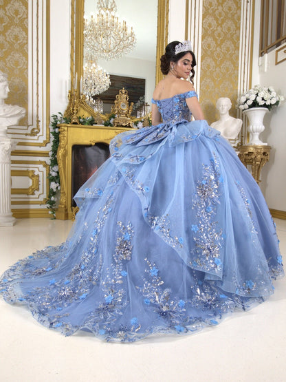 Back view of a woman wearing blue quinceanera ball gown with seven-layer tulle skirt, floral beaded appliques, and lace-up train