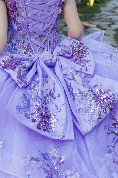 Close-up of a woman wearing lilac quinceanera ball gown ribbon with floral beaded appliques and seven-layer tulle skirt