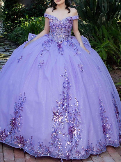Front view of a woman wearing lilac quinceanera ball gown with seven-layer tulle skirt, floral beaded appliques, and lace bodice
