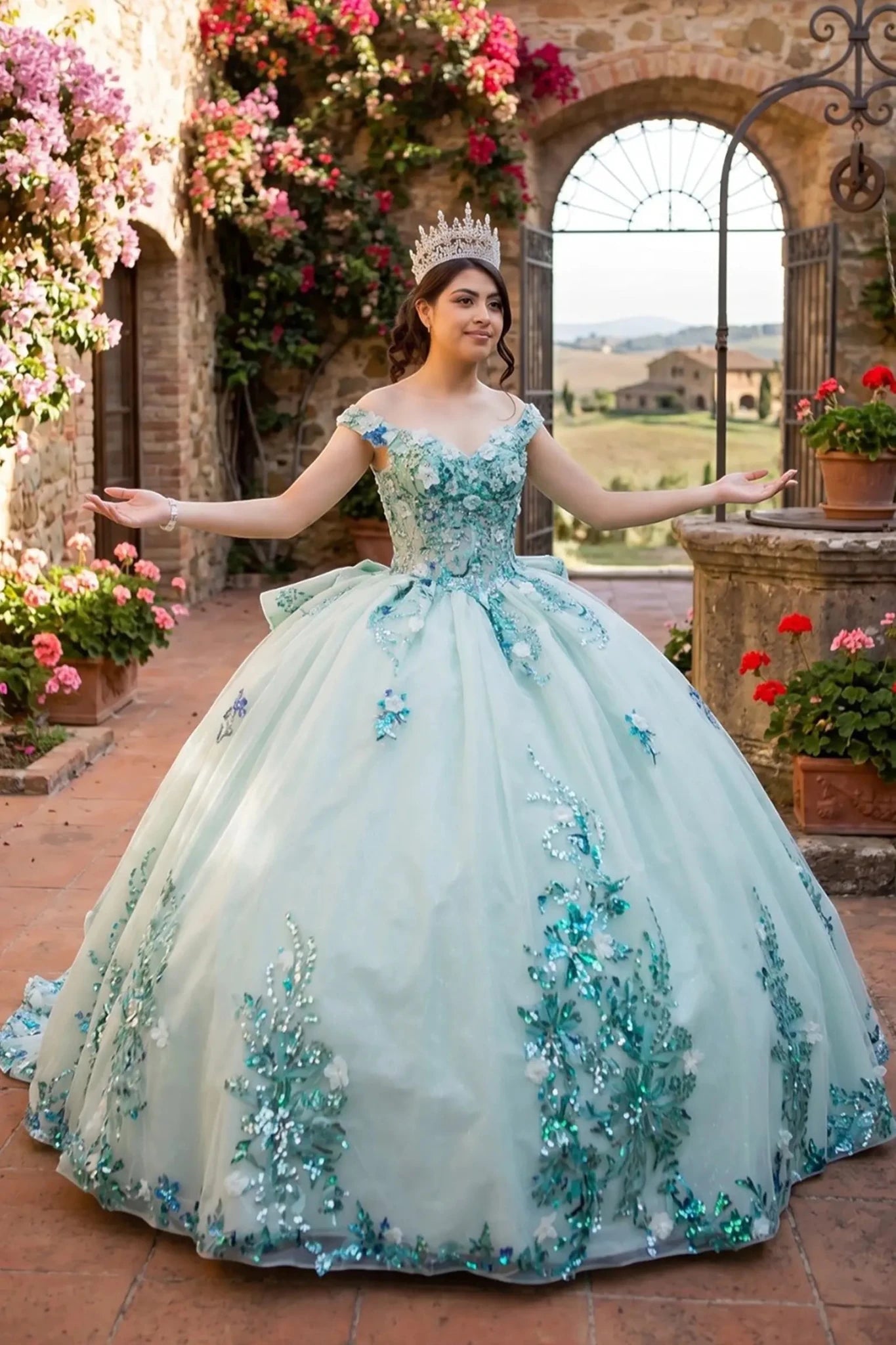 Front view of a woman wearing sage quinceanera ball gown with sweetheart neckline, floral beaded appliques, and seven-layer tulle skirt