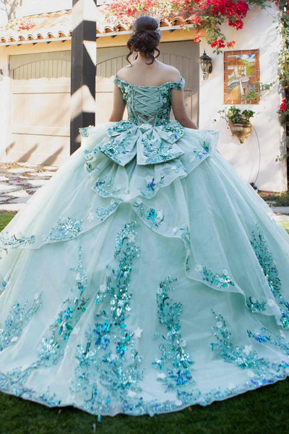 Shown in a back view, the Sage quinceañera dress has lace-up back and floral bow over the layered ball skirt.