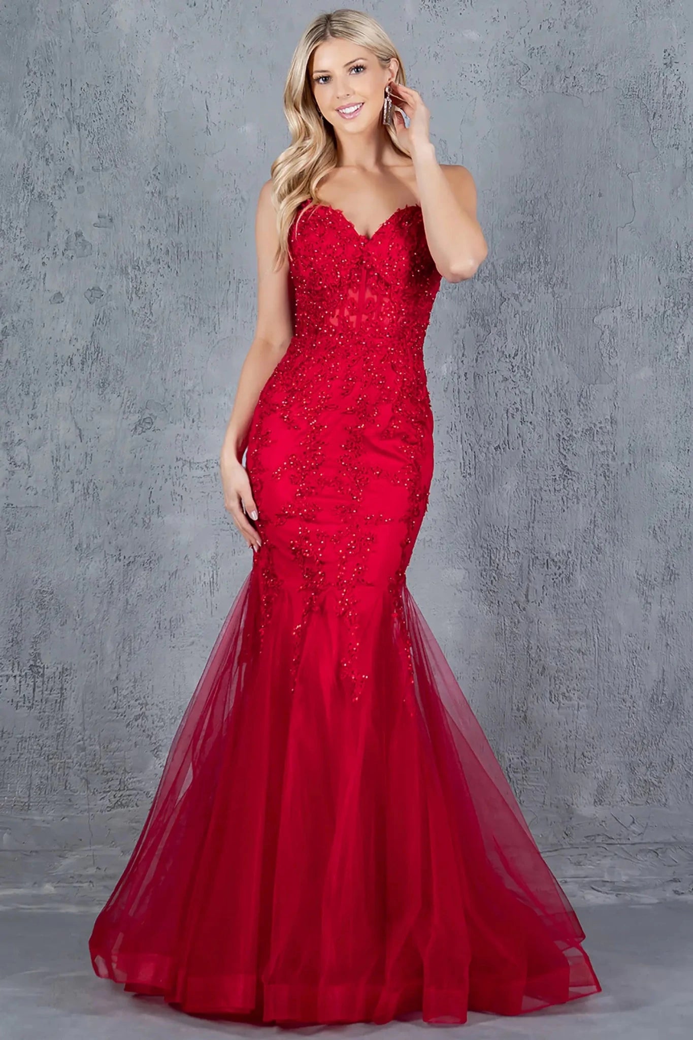Full front view of a women wearing burgundy mermaid prom dress with lace corset bodice and embroidered detail.