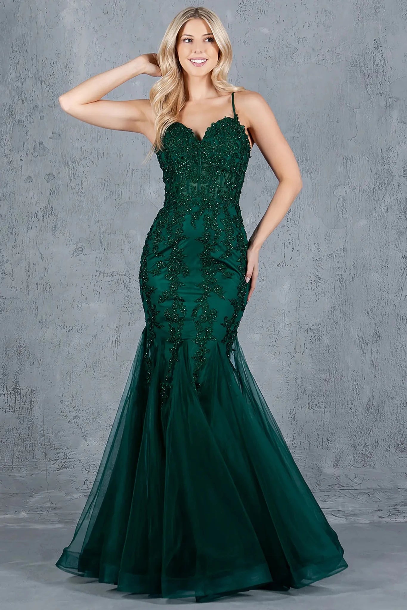 Full front view of a women wearing green mermaid prom dress with embroidered corset bodice and tulle overlay.