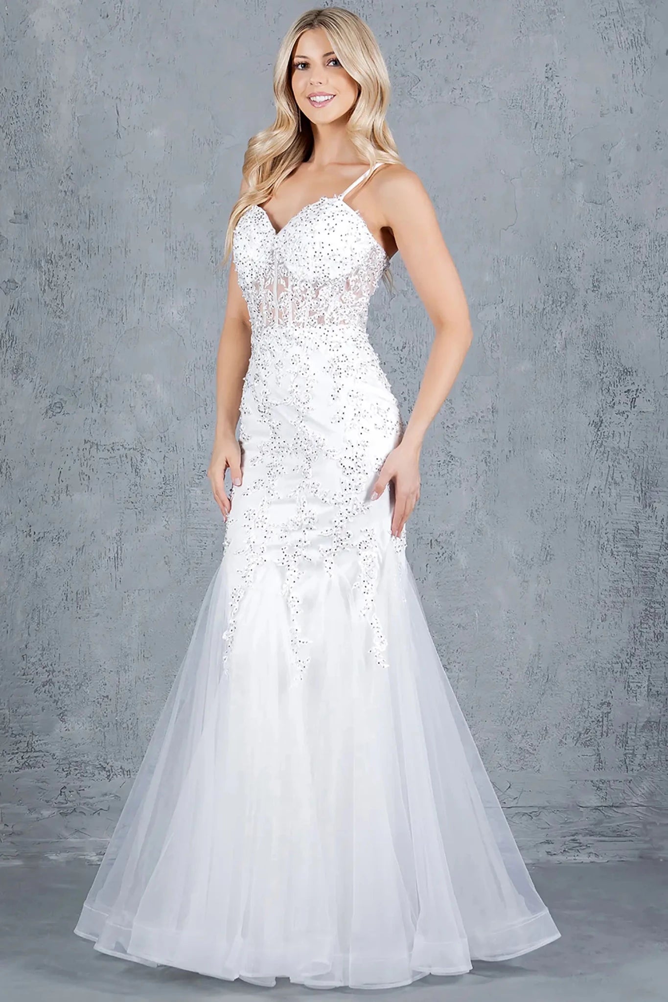 A full-length front view of a woman wearing a silver formal prom dress featuring a lace-up corset and figure-flattering fitted shape.