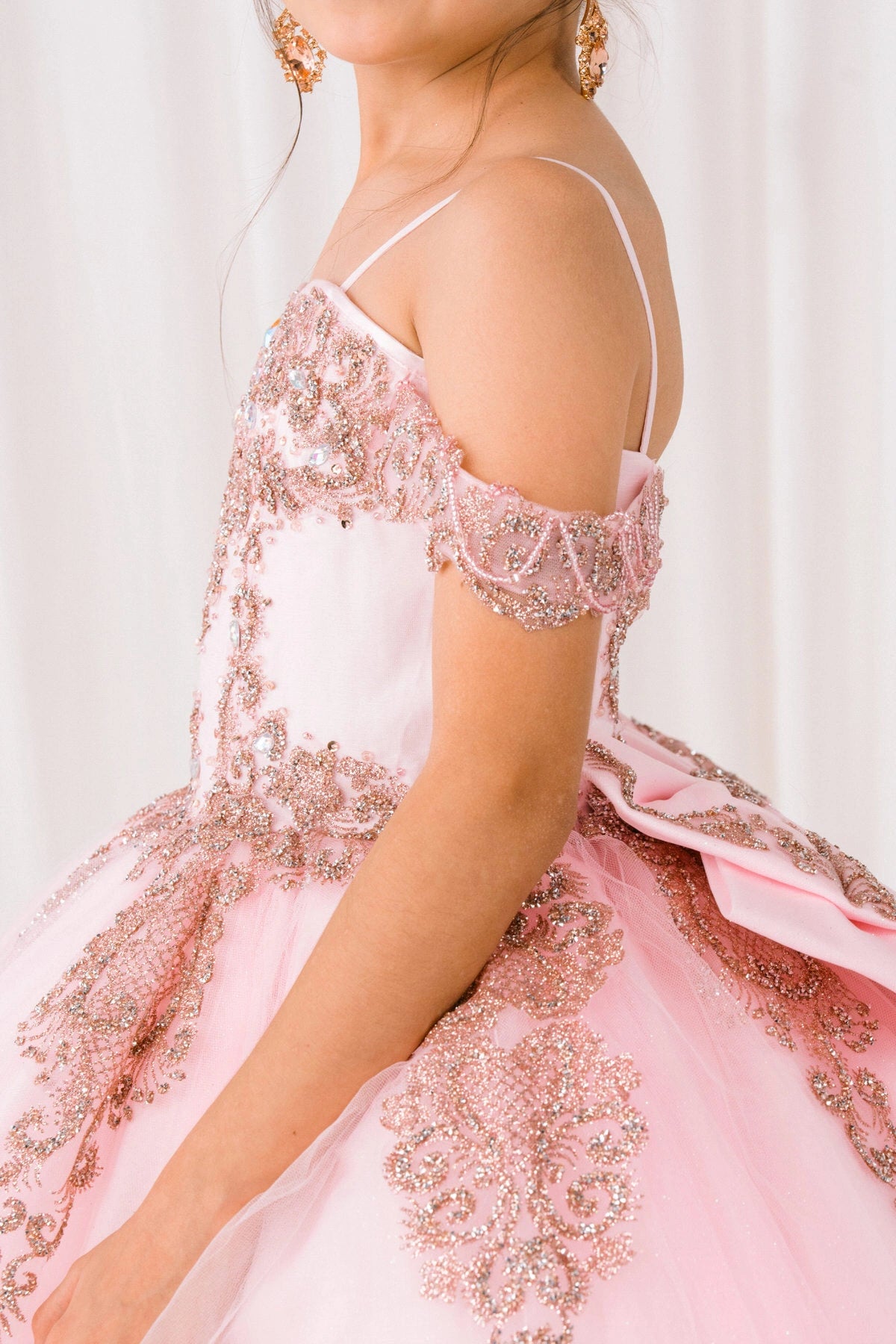 Shown in a bodice detail, the Pink mini quince dress has thin shoulder straps, off-shoulder trim and floral bodice.
