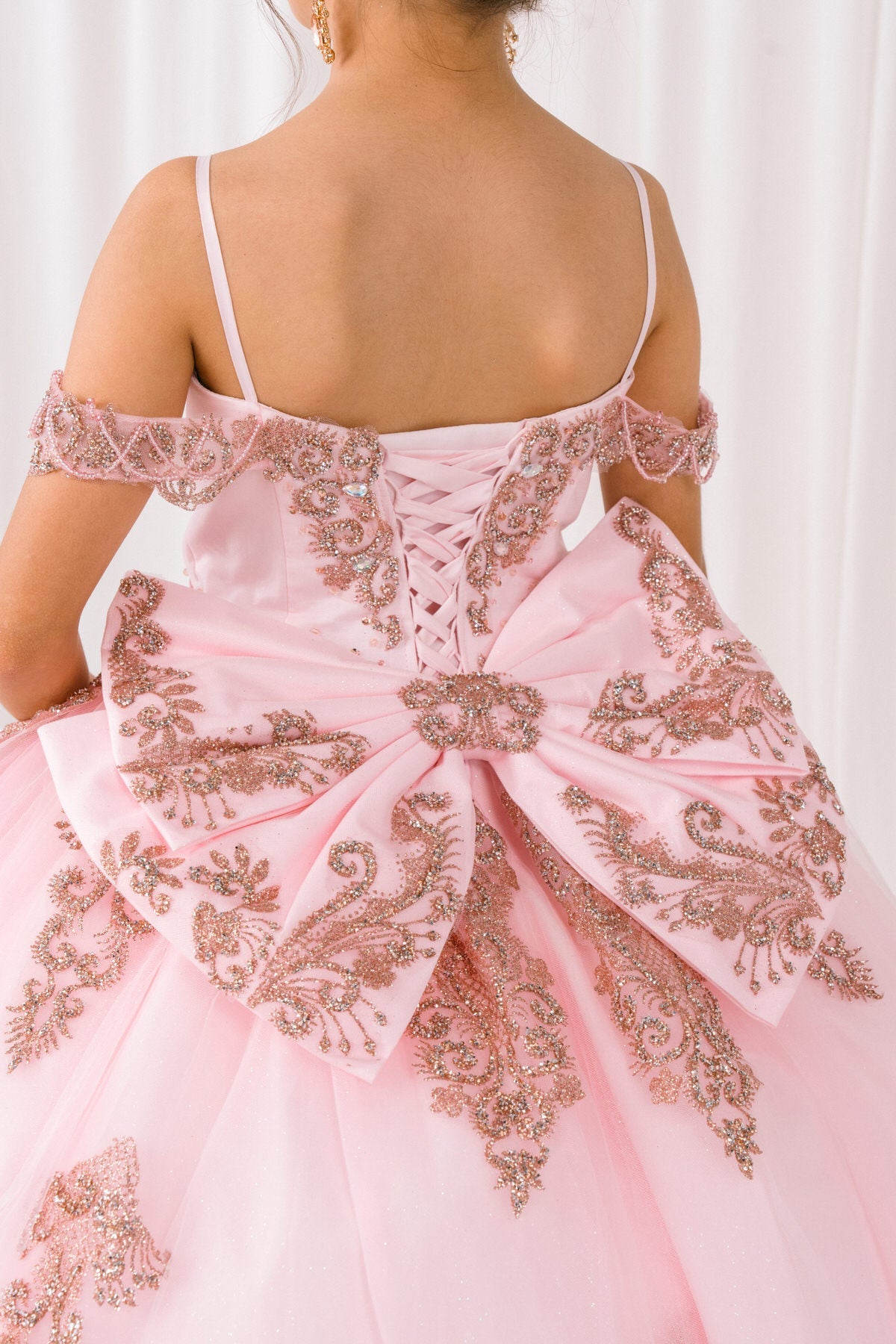 Pink front view kids mini quinceañera mini quince dress with sparkle bead details, gold embroidery and layered tulle skirt.