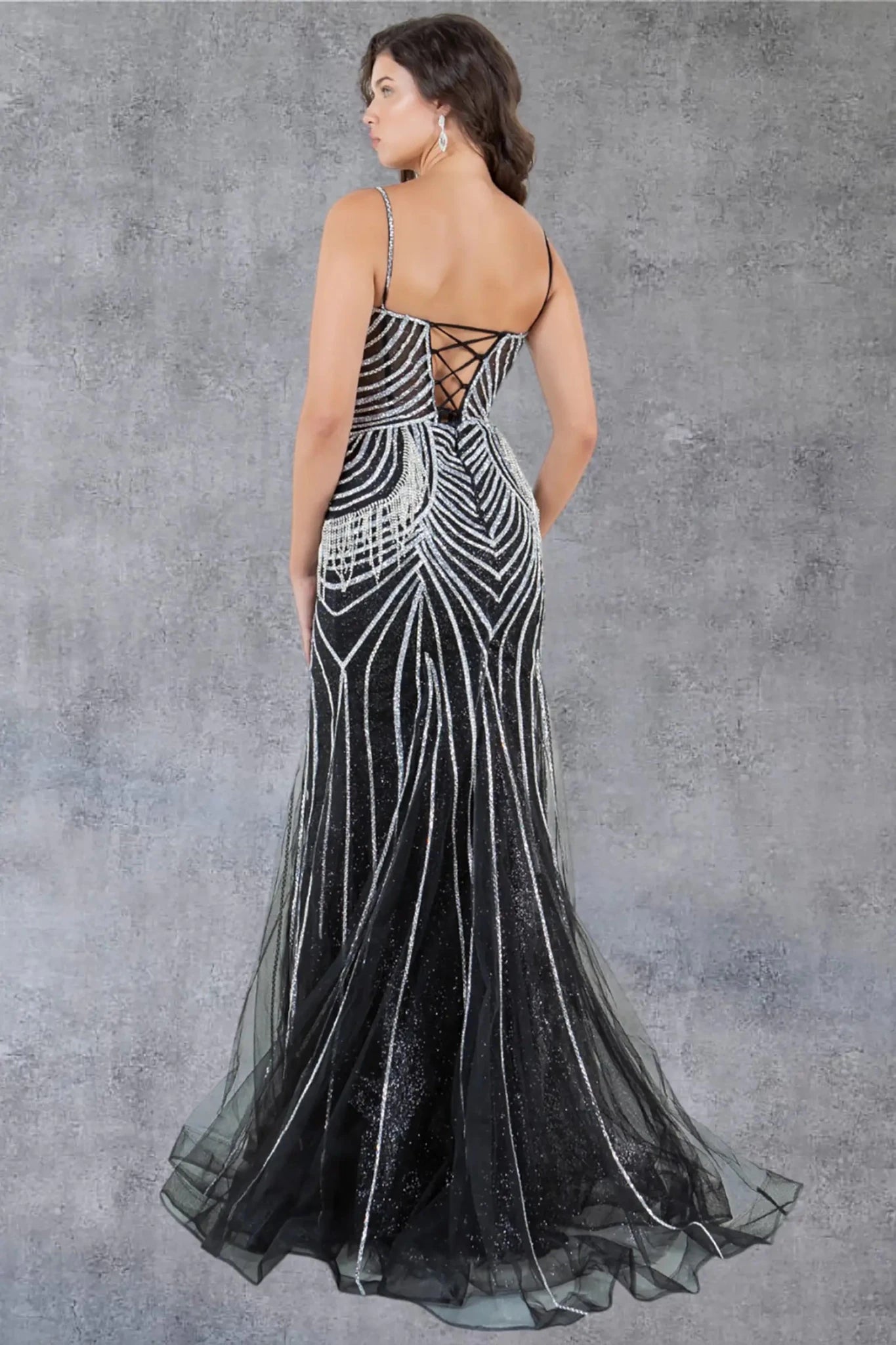 A full back view of a woman wearing a black formal dress with a lace-up corset closure.