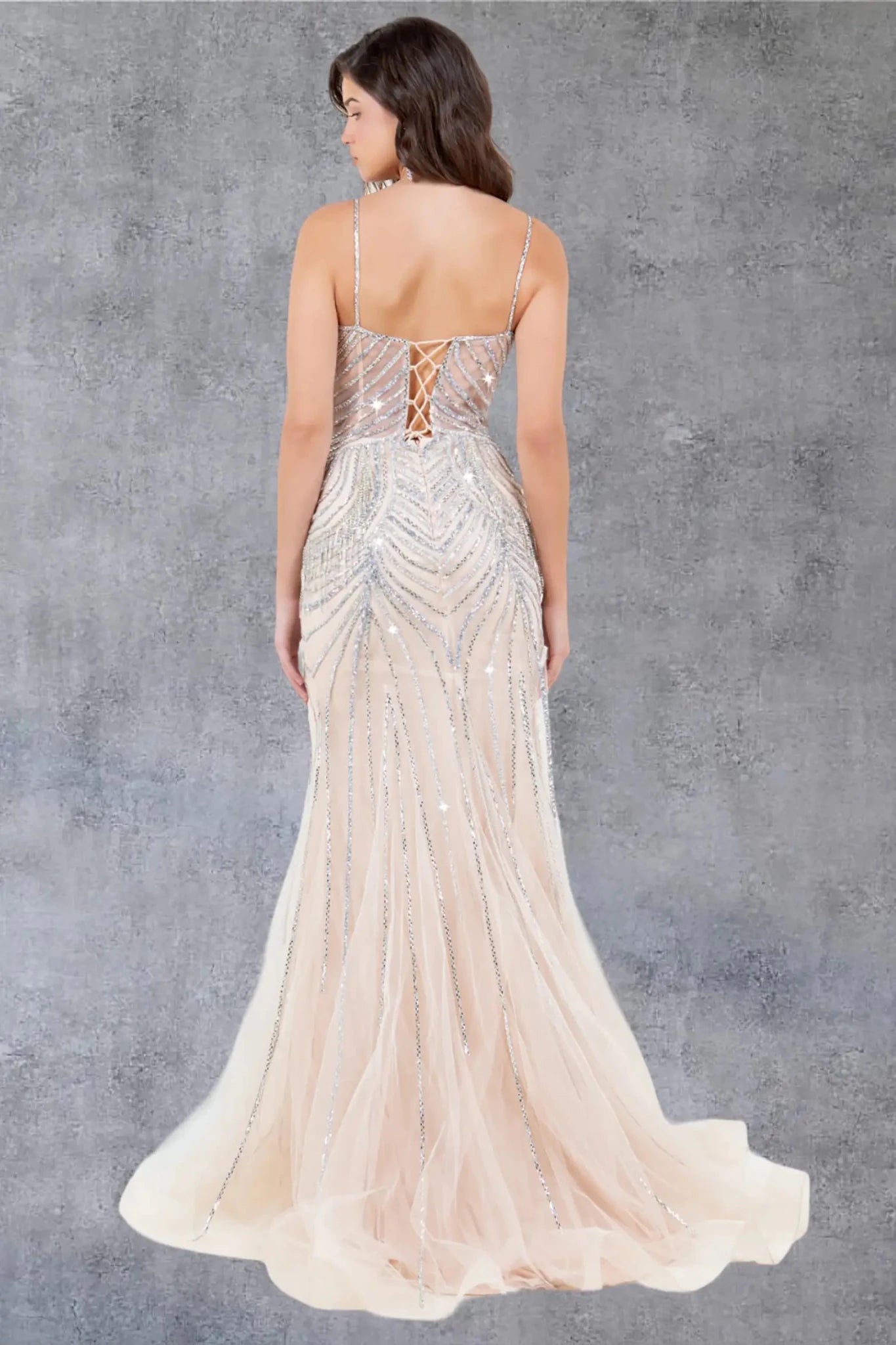 A full back view of a woman wearing a brown formal dress featuring a lace-up corset back.