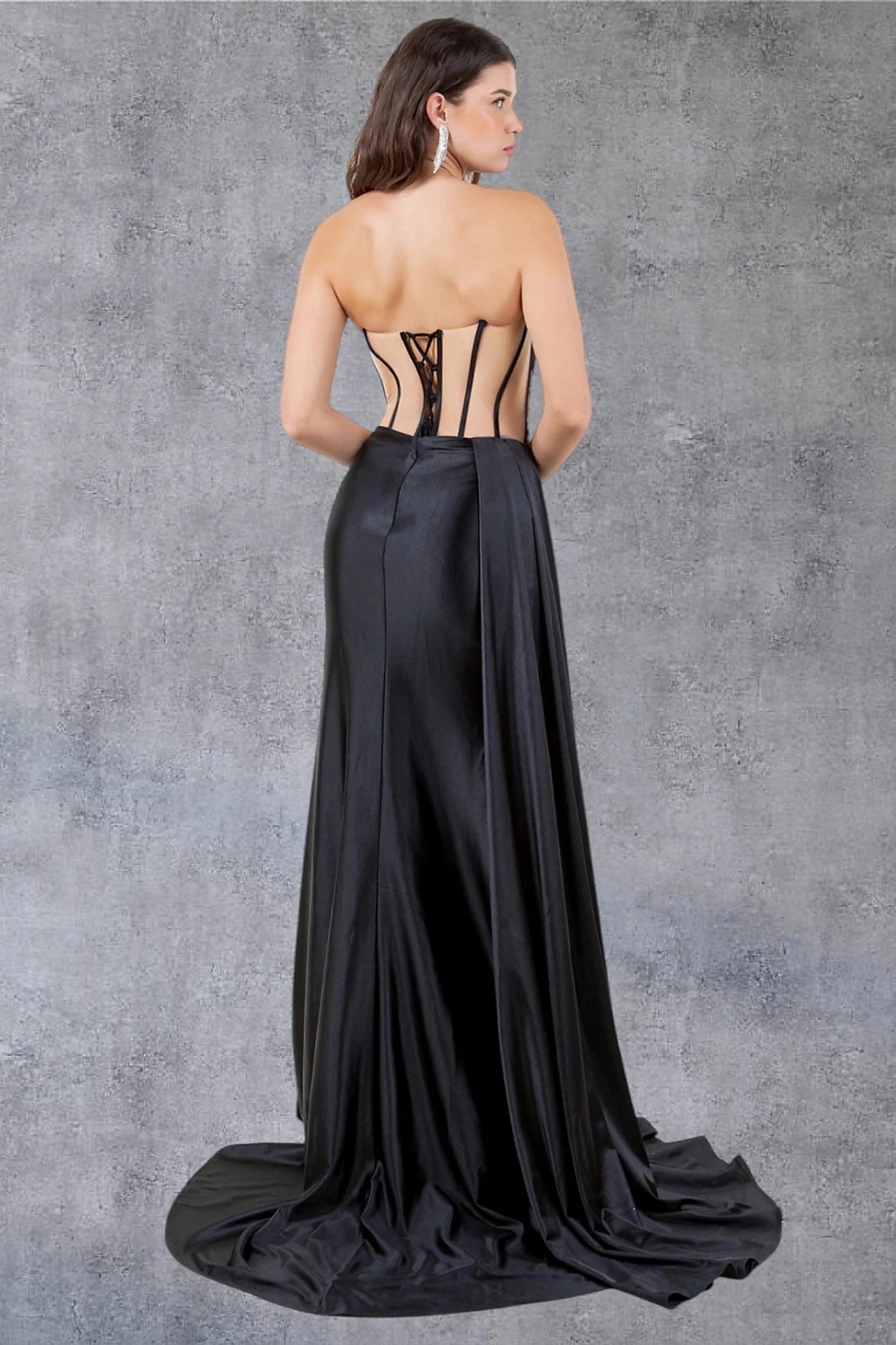 Black prom dress styled with sheer cutout details creating corset appearance and lace back up