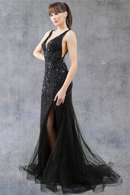 A side profile view of a woman wearing a black tulle prom dress, highlighting the flowing skirt and slit.