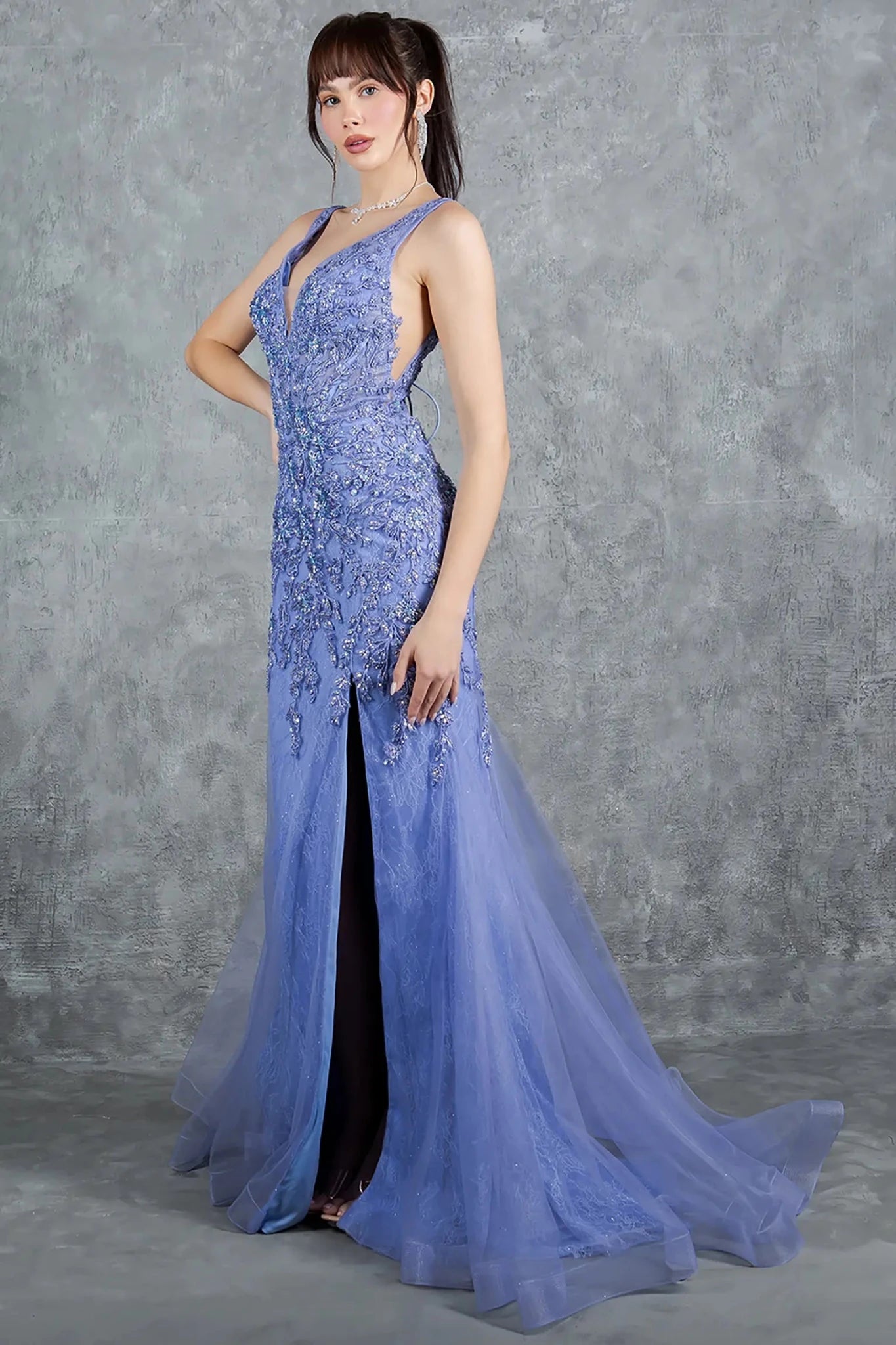 A side profile view of a woman wearing a blue prom dress, showcasing soft tulle movement and graceful flow.