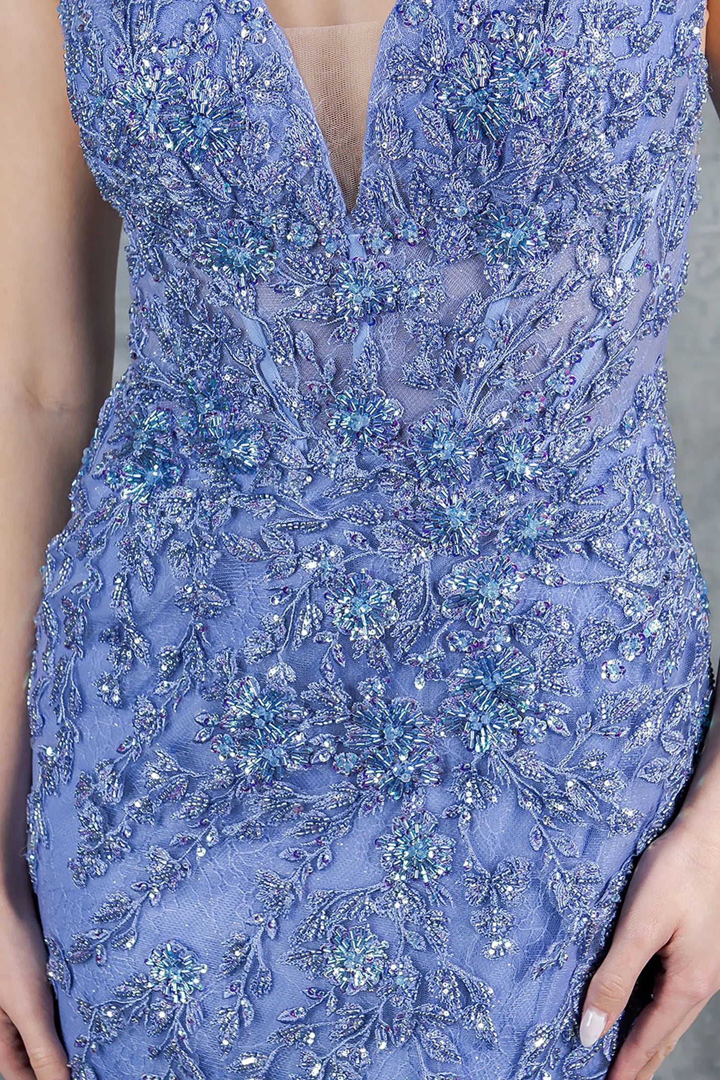 A close-up view of a woman wearing a blue lace bodice with sequin embellishment.