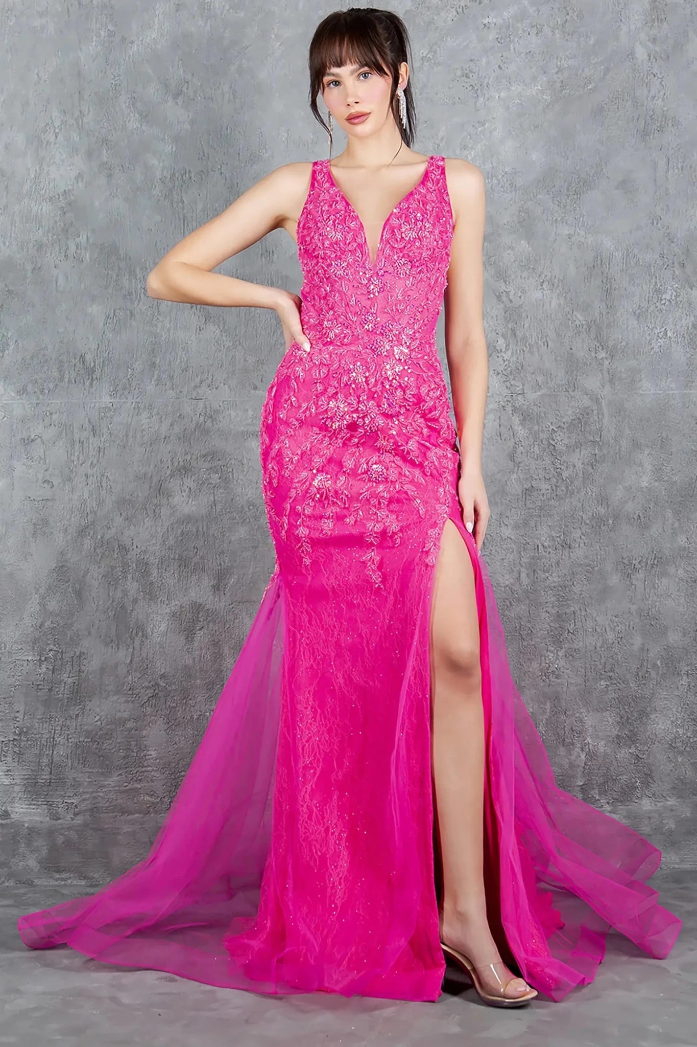 Full front view of a women wearing fuchsia sleeveless prom dress with plunging lace bodice and slit.