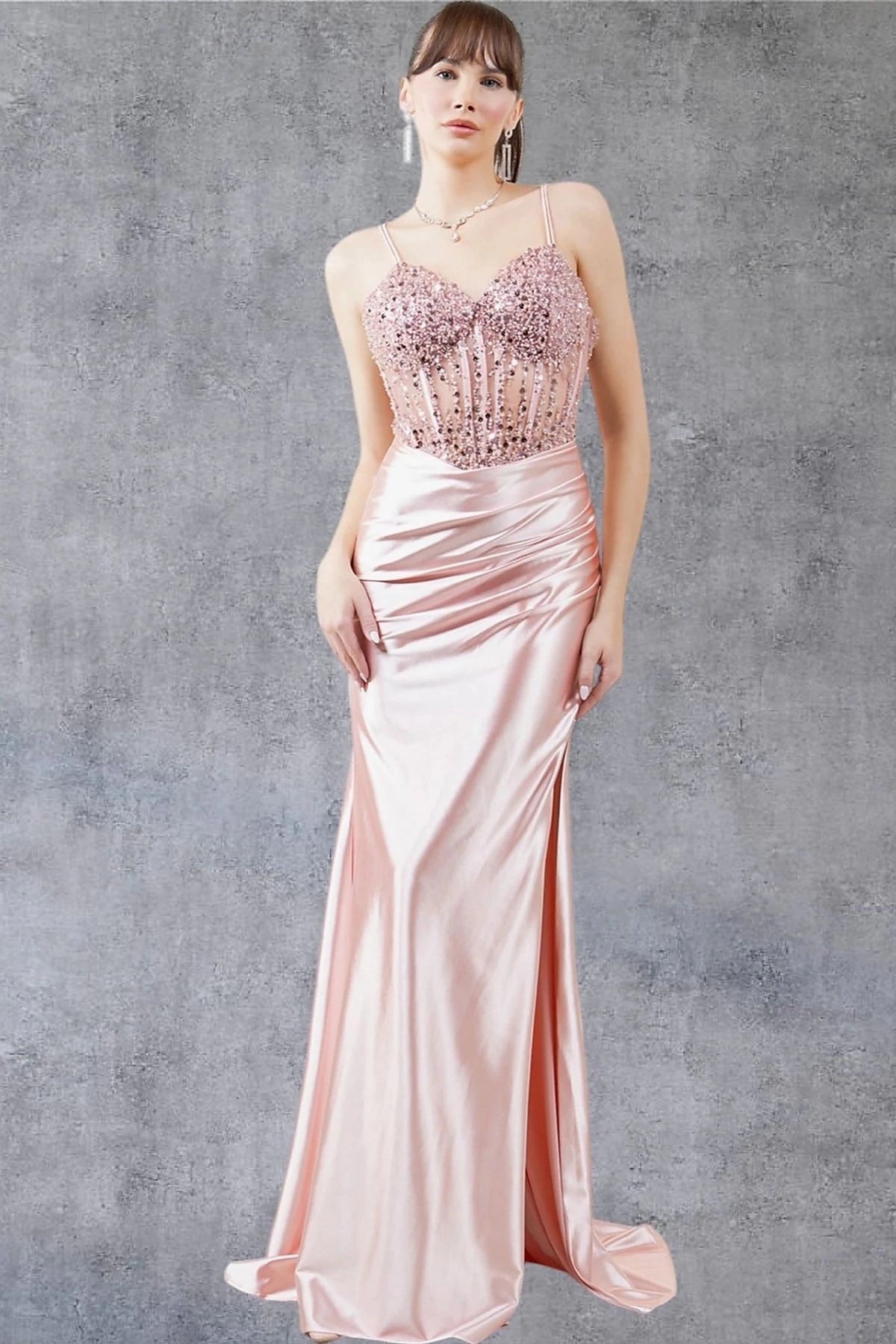 Intricate features stand out across rose Gold prom dress showcasing floor-length skirt with ruching at waist.