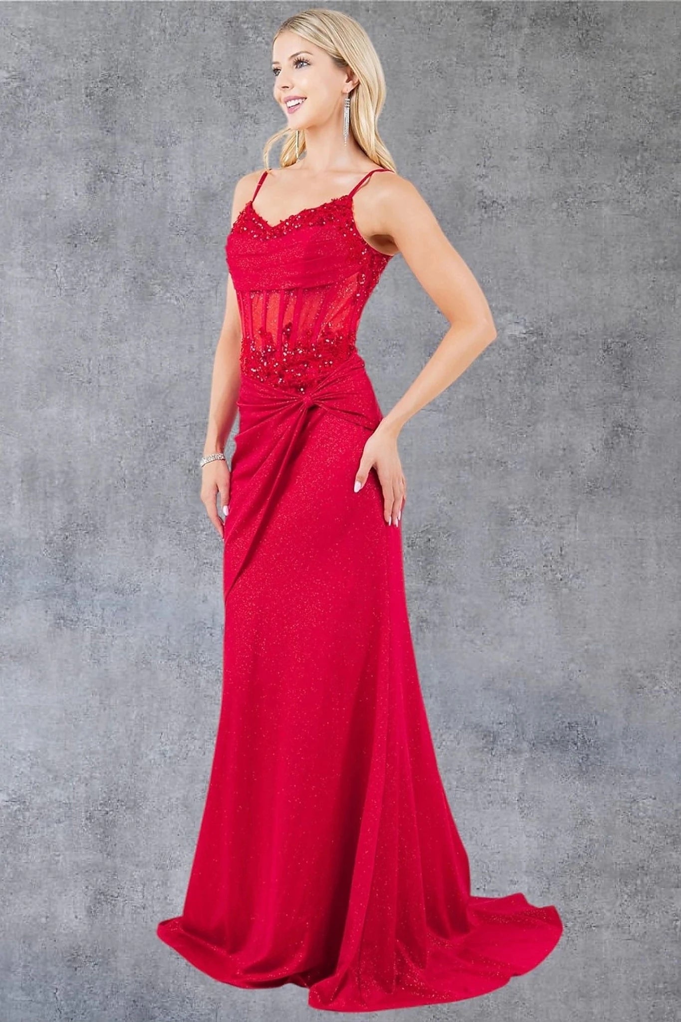 Red prom dress styled with spaghetti straps and ruched waist detail