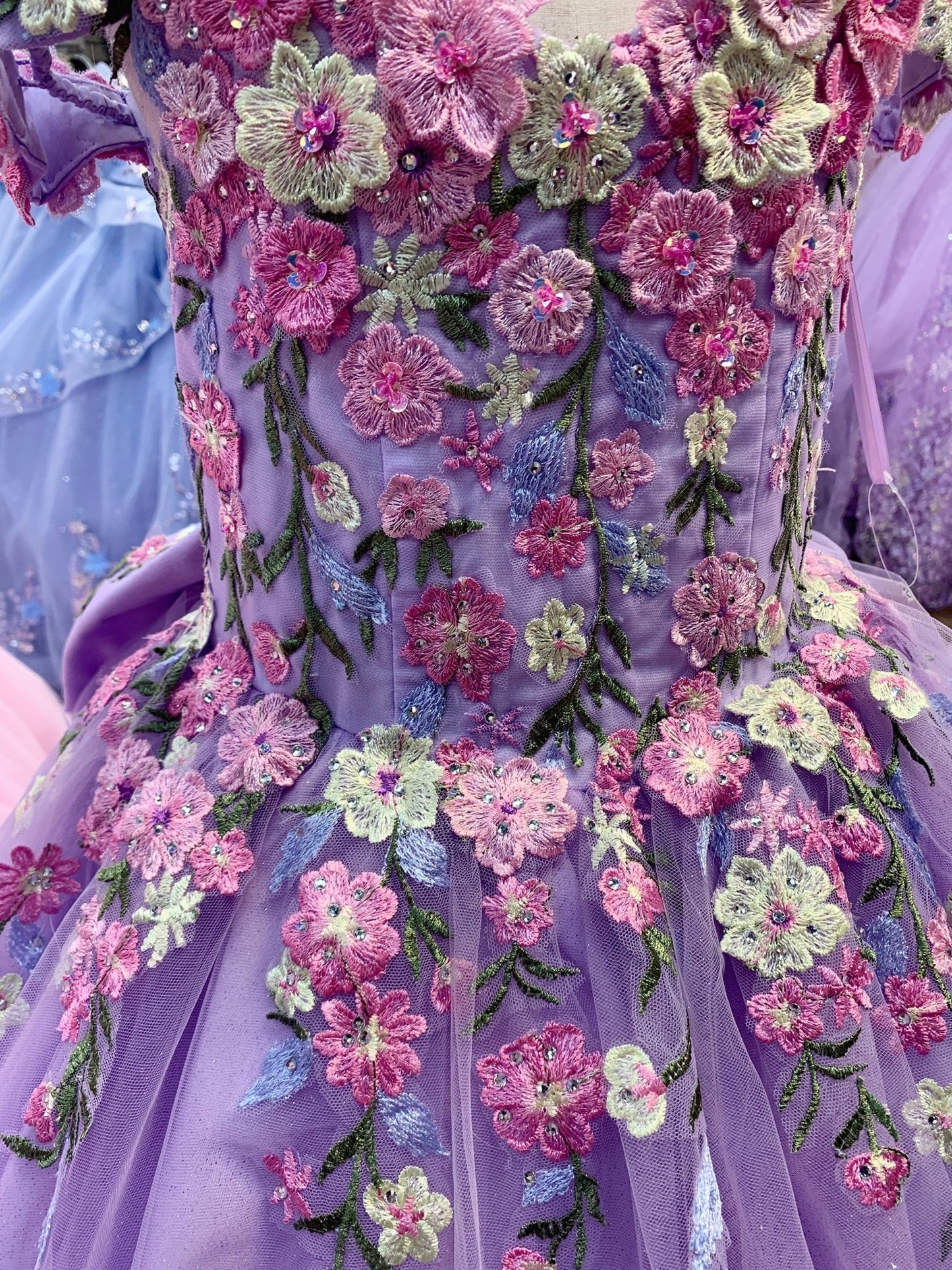 Lilac detail view kids mini quinceañera mini quince dress with multicolor daisy embroidery.