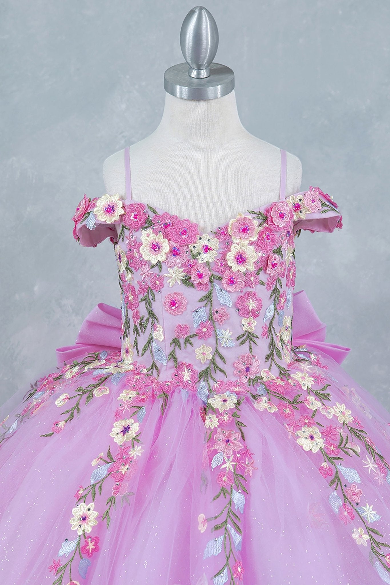 Pink front zoom kids mini quinceañera mini quince dress with multicolor daisy embroidery and large detachable bow.