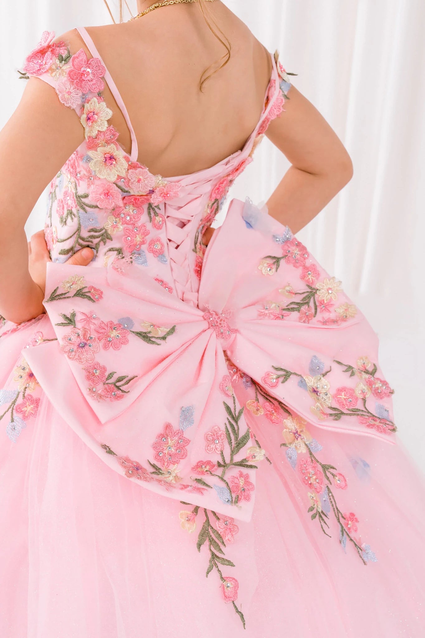 Pink front view kids mini quinceañera mini quince dress with floral lace and bow detail.