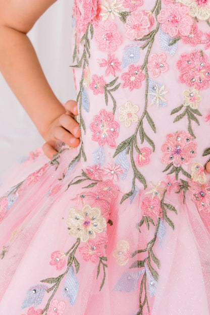 Close-up view reveals pink detail zoom kids mini quinceañera mini quince dress with floral lace embroidery.
