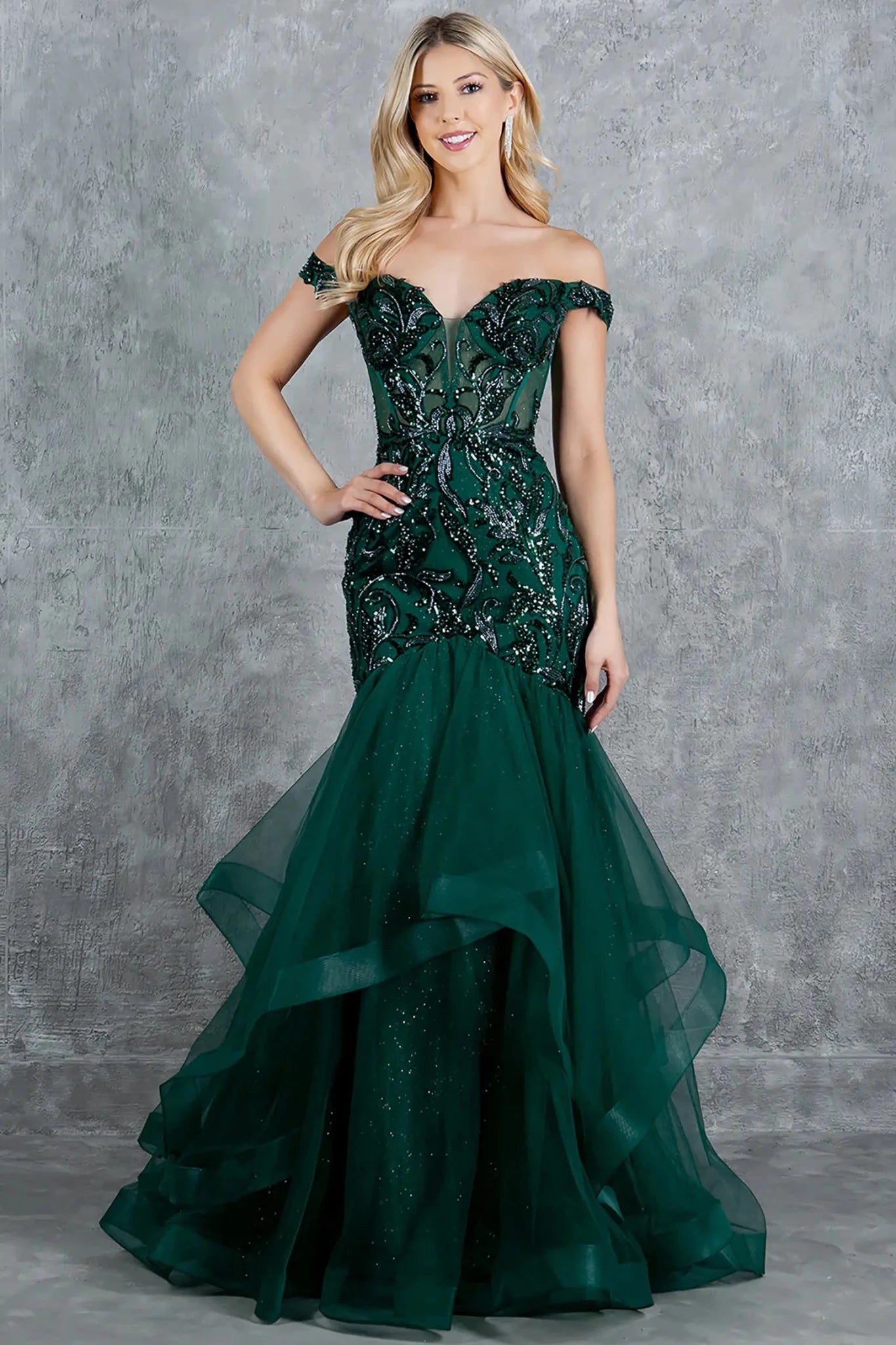 Full front view of a women wearing green off-shoulder mermaid prom dress with embroidered corset bodice and tulle skirt.