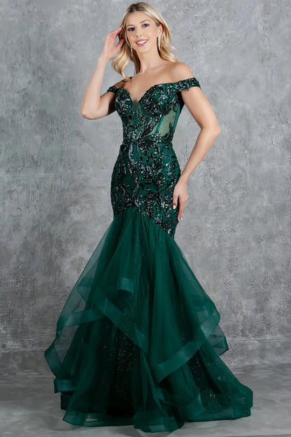 A full-length front view of a woman wearing a green formal prom dress featuring a lace-up corset and voluminous tulle skirt.