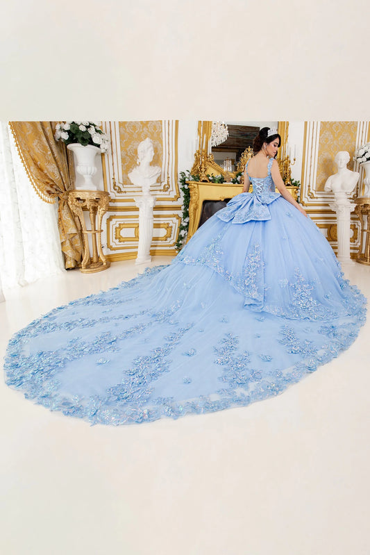 Woman in a blue quinceanera ball gown with a long train in an elegant room.
