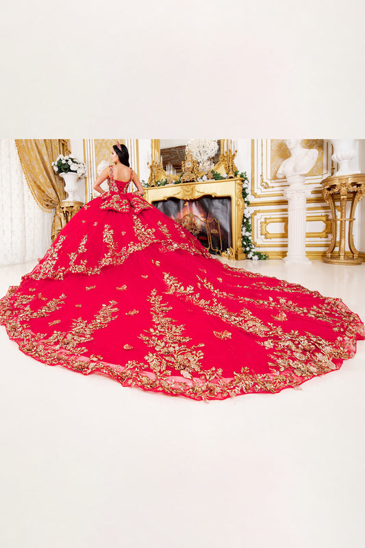 Red quince ball gown with gold embroidery in a decorated room.