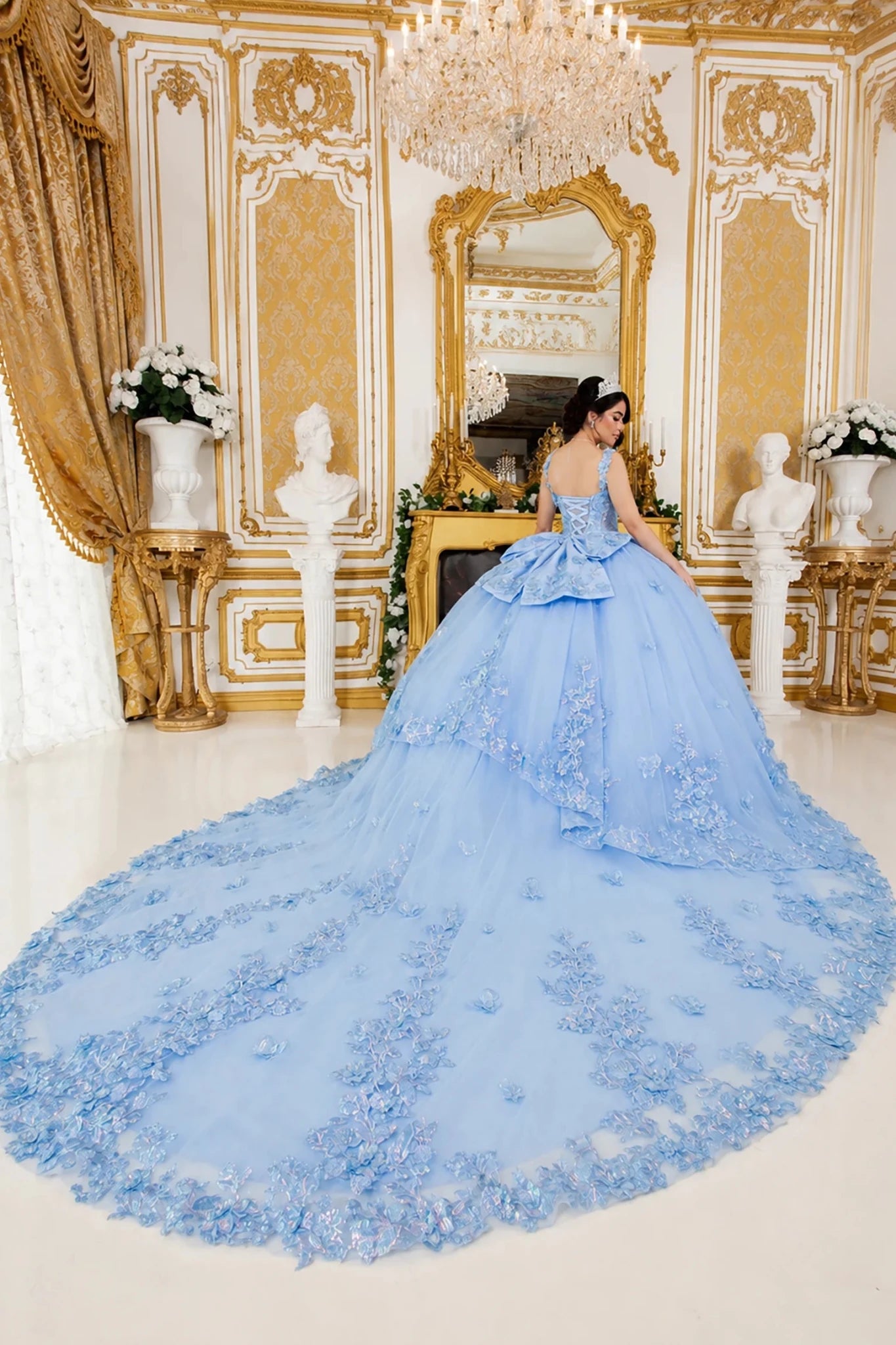 blue quinceanera dress with gold floral embroidery and large train spread across the floor
