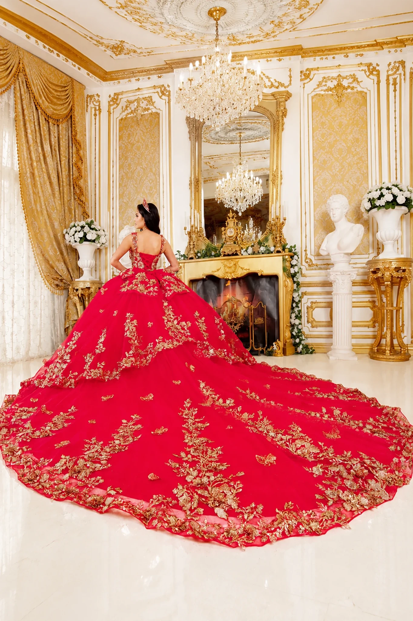 red quinceanera dress with gold floral embroidery and large train spread across the floor