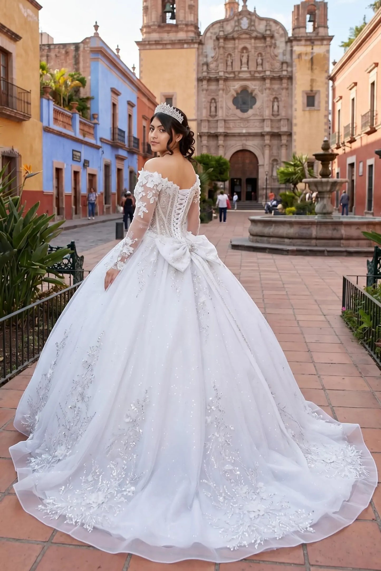 Side view of an off-white quinceanera dress with sweetheart neckline, lace appliques, beadwork, sheer sleeves, and layered glitter tulle skirt
