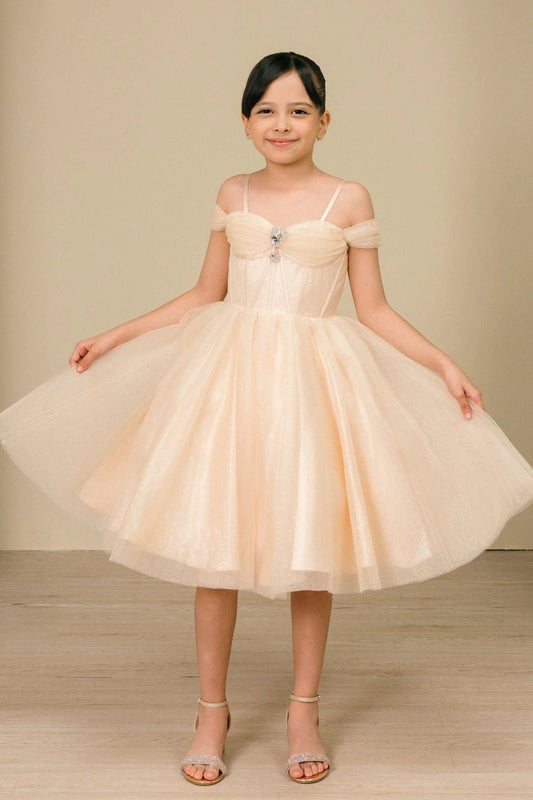 Shown in a front view, the Champagne girls formal dress has thin straps and off-shoulder bands over a full tulle skirt.