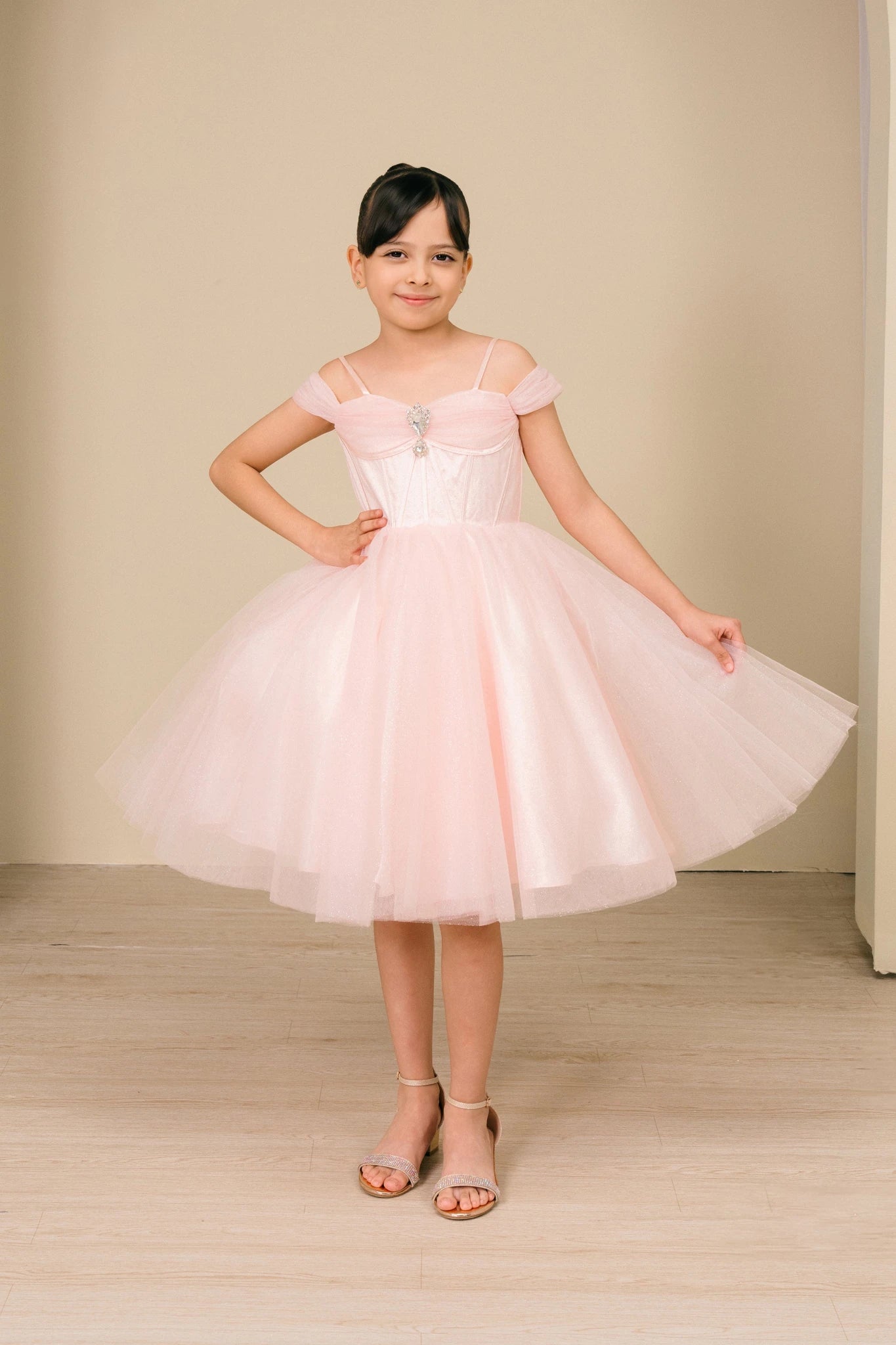 A Pink Off-Shoulder Tulle flower girl dress with Center Rhinestone.