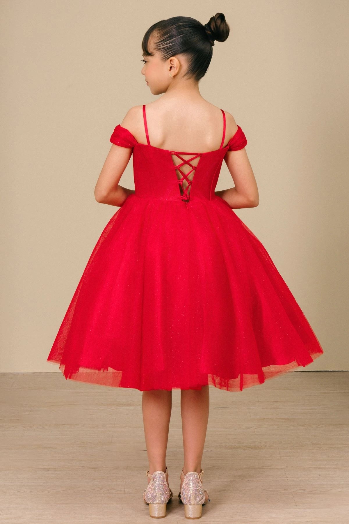 Shown in a back view, the Red girls formal dress has off-shoulder bands and lace-up closure above the flared skirt.