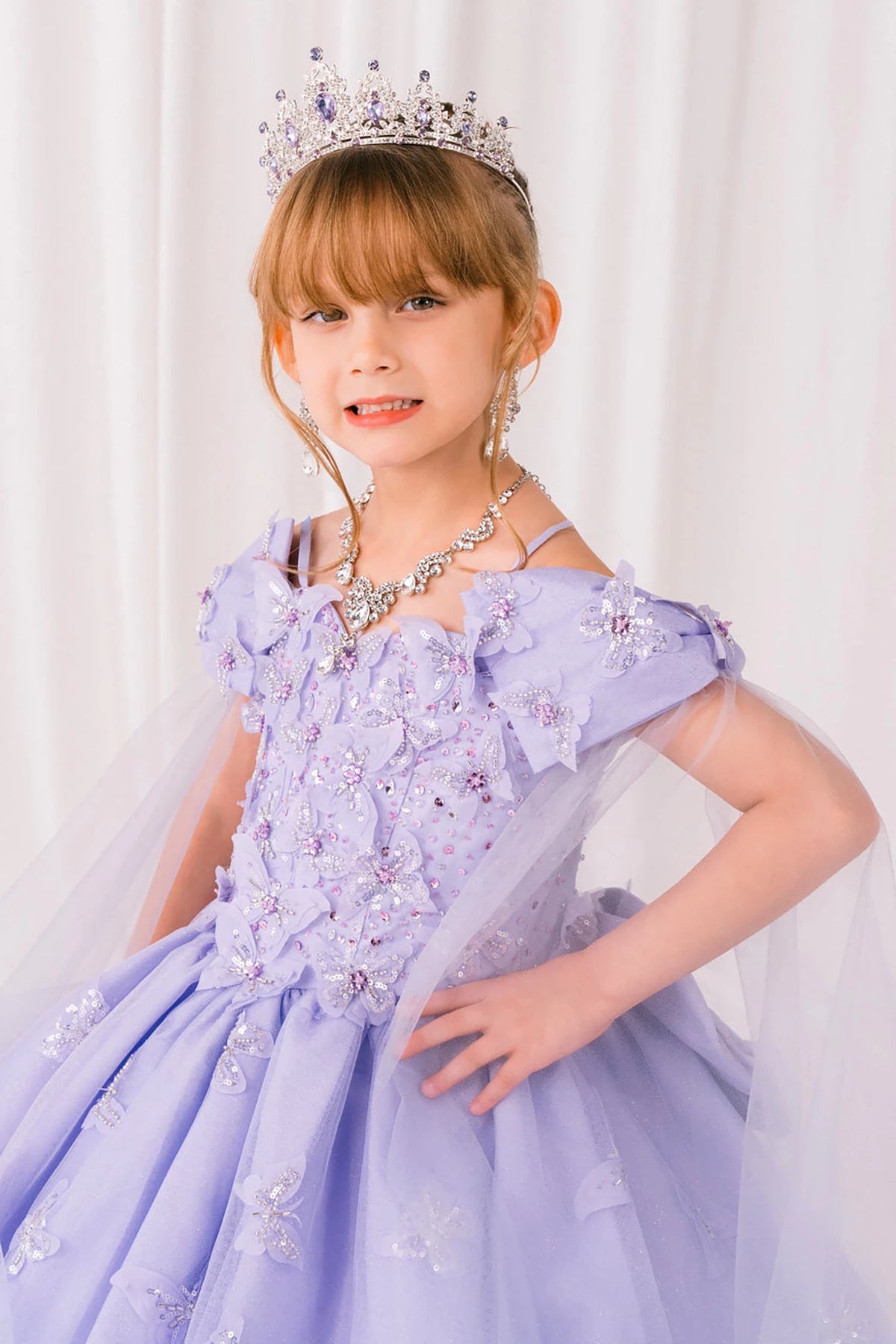 Lilac front view kids mini quinceañera mini quince dress with glitter puff sleeves, butterfly applique and sheer train.