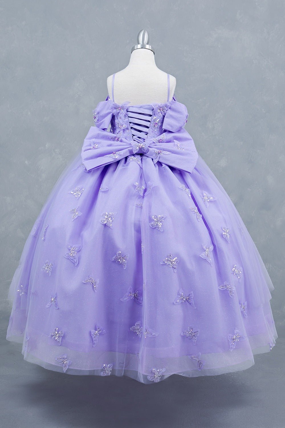 Lilac back view kids mini quinceañera mini quince dress with glitter puff sleeves, butterfly and back bow detail.