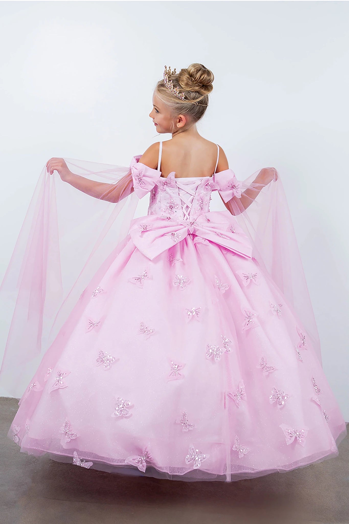 Pink front view kids mini quinceañera mini quince dress with glitter puff sleeves, bow detail and sheer train.