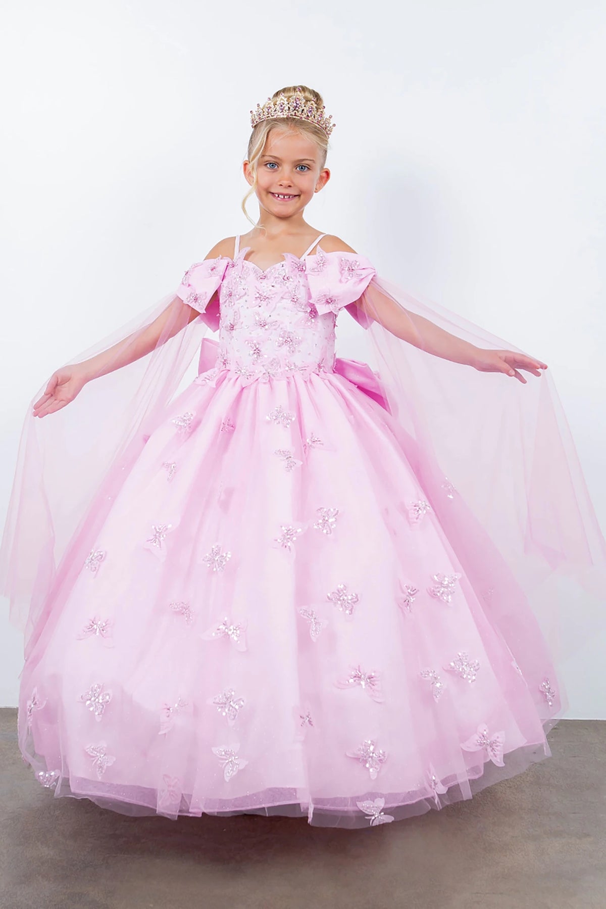 Pink front view kids mini quinceañera mini quince dress with glitter puff sleeves and sheer shoulders.