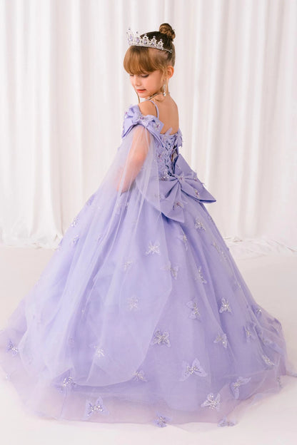 Young girl in a lilac mini quince princess dress with a tiara against a white curtain background