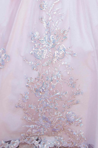 Skirt detail of a rose gold quinceanera dress with layered shimmering tulle fabric, scattered floral appliques, and chapel-length train