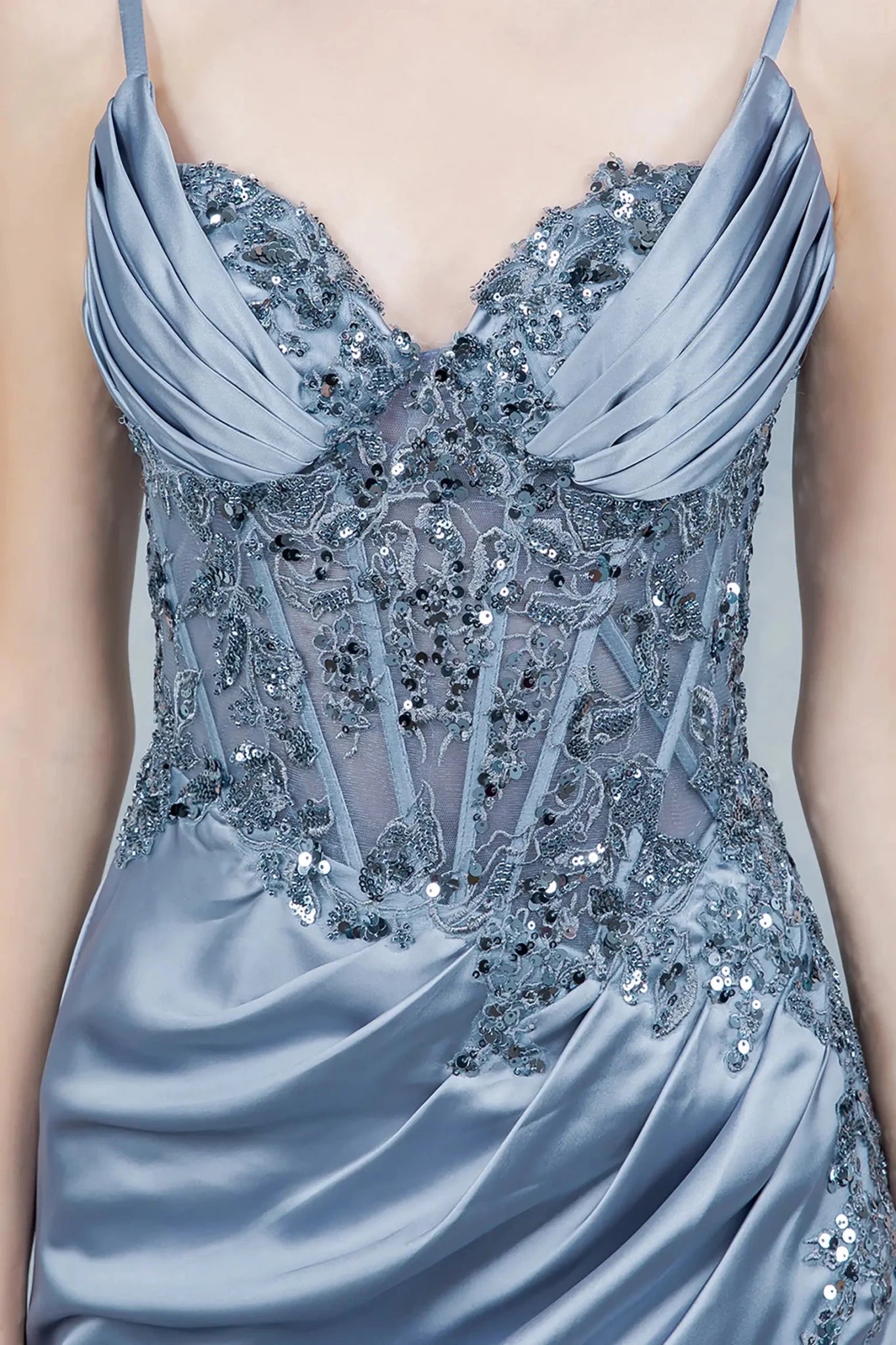 A close-up view of a woman wearing a blue lace corset bodice with sheer paneling.
