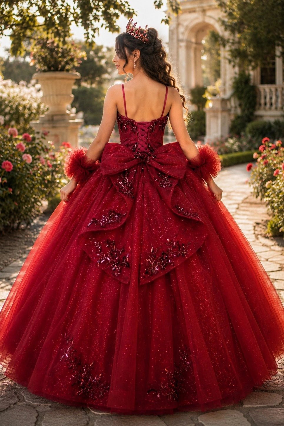 Displayed in a back view, the Burgundy mini quince dress has lace-up closure, large bow and layered glitter skirt.