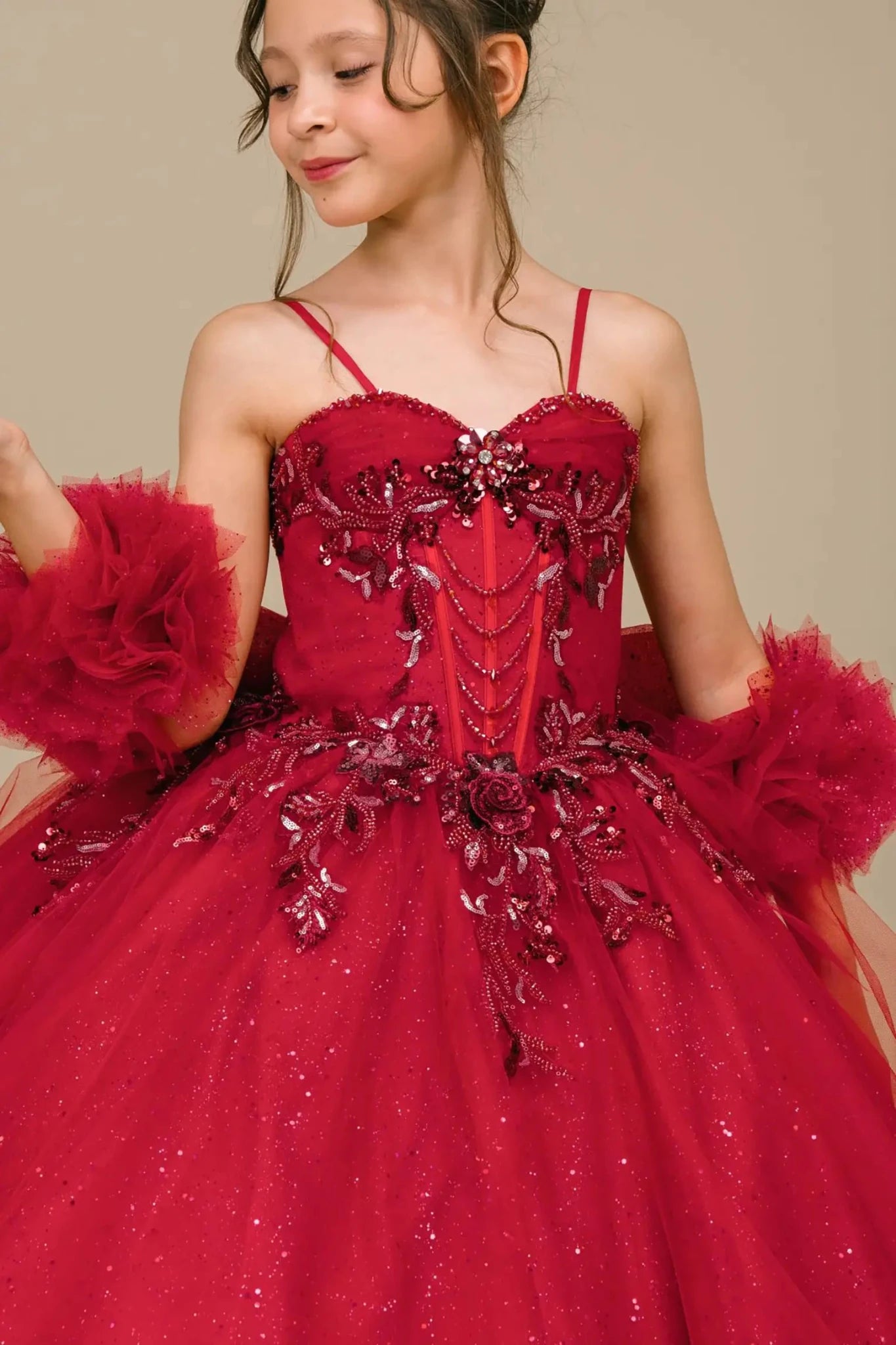 Close-up front-facing view of burgundy mini quinceañera mini quince dress with beaded floral appliqué bodice, draped detailing, and matching tulle arm cuffs.