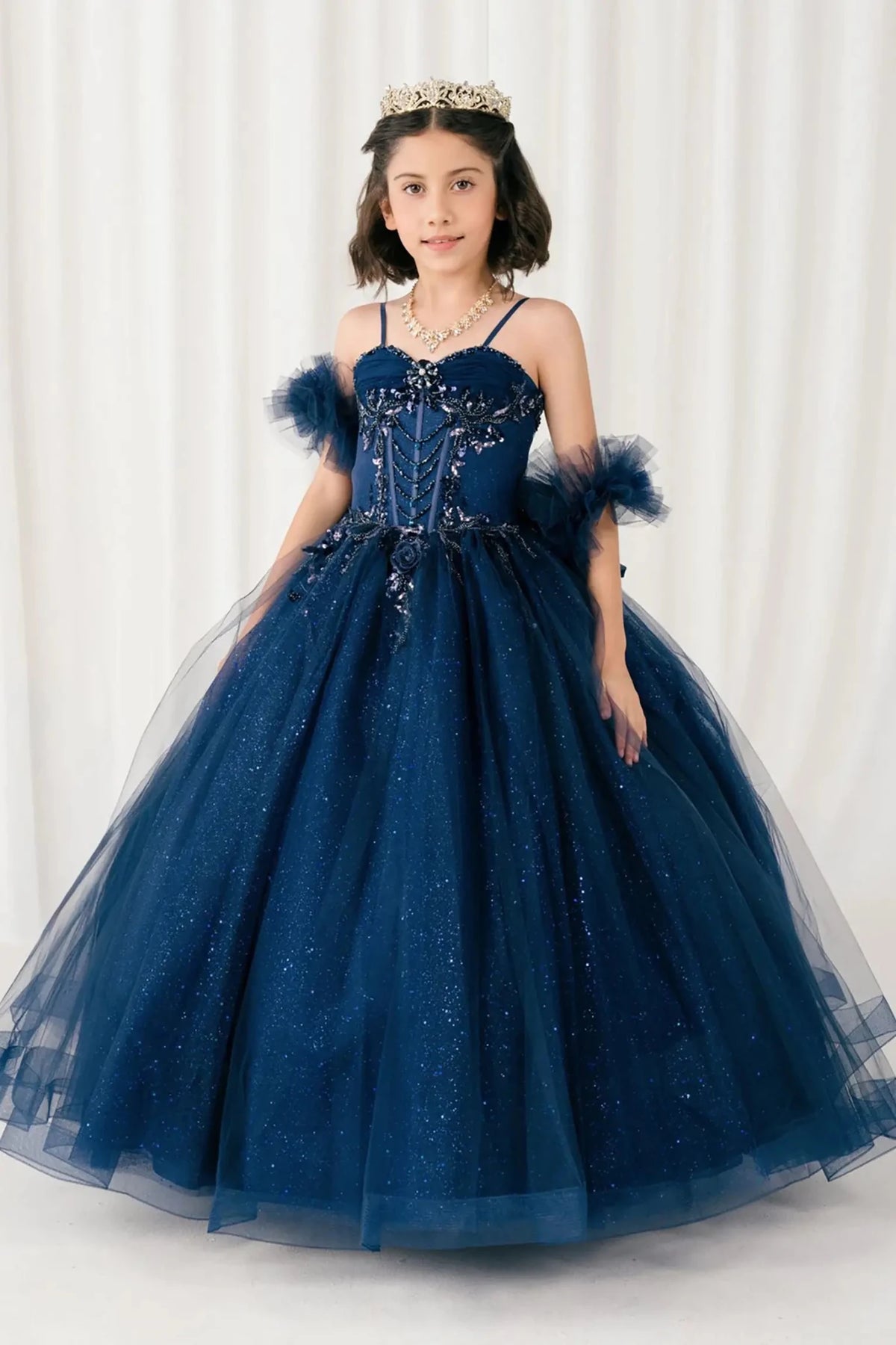 Front view of Navy mini quinceañera mini quince dress with beaded bodice, floral appliqué, draped details, sparkling tulle skirt, and matching tulle arm cuffs.