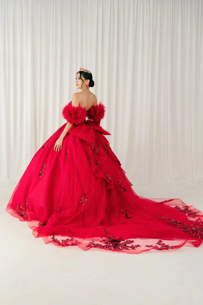 Back view – Full back view of red quinceañera ball gown with dramatic bow accent and extended glitter tulle train.