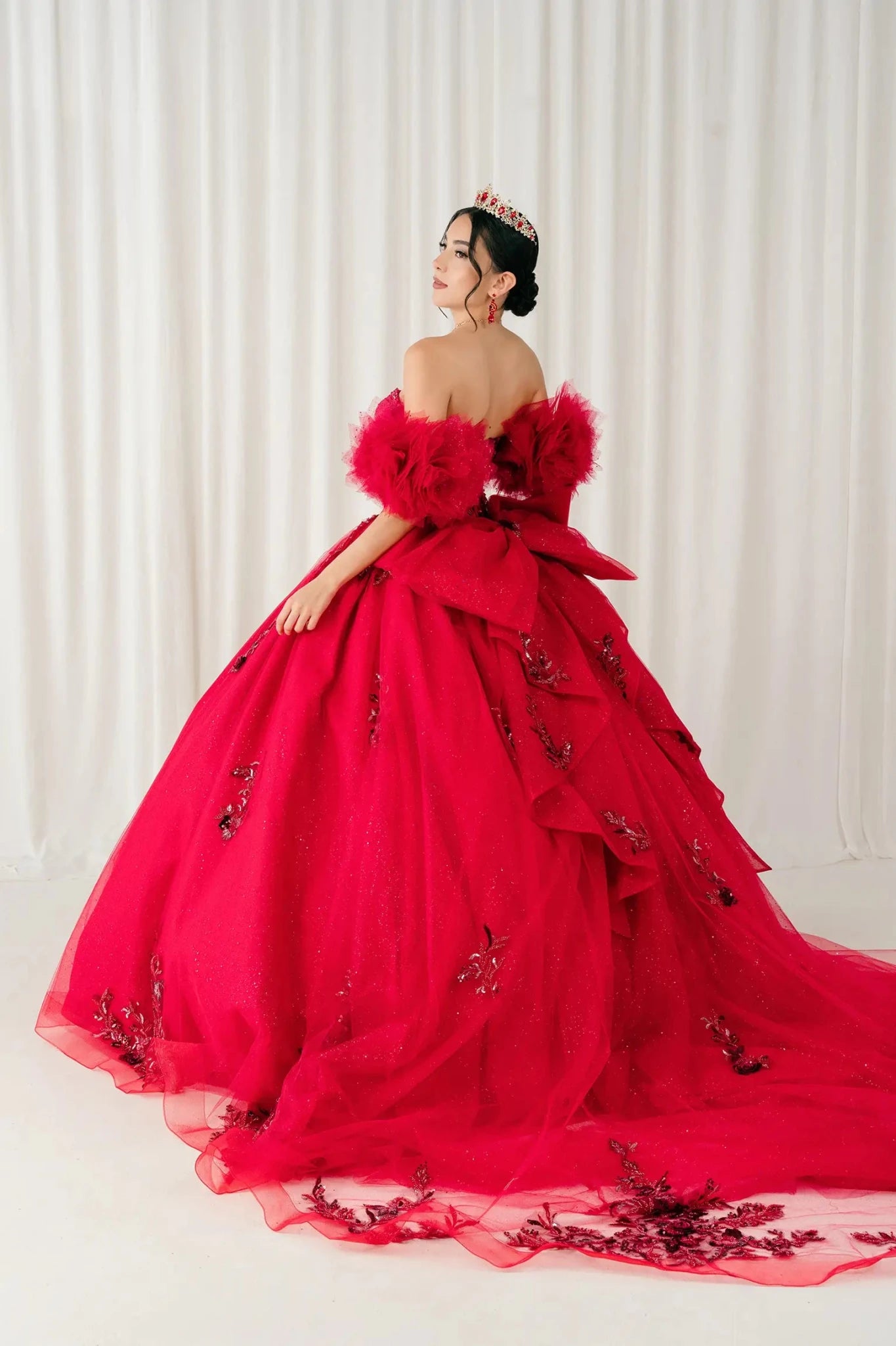 Back detail view – Close-up back detail of red quinceañera ball gown focusing on bow construction and layered tulle texture.