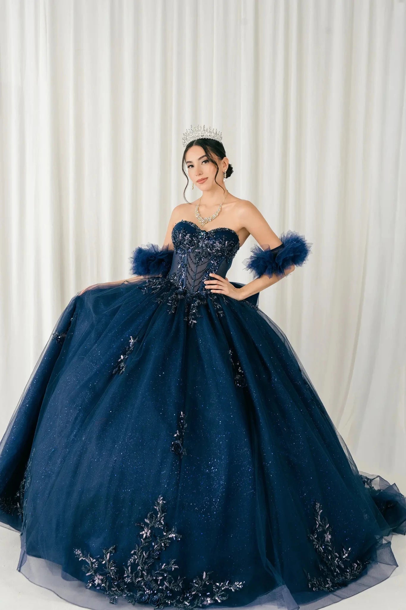 Front full-length view of navy blue sweetheart ball gown with beaded corset and voluminous skirt
