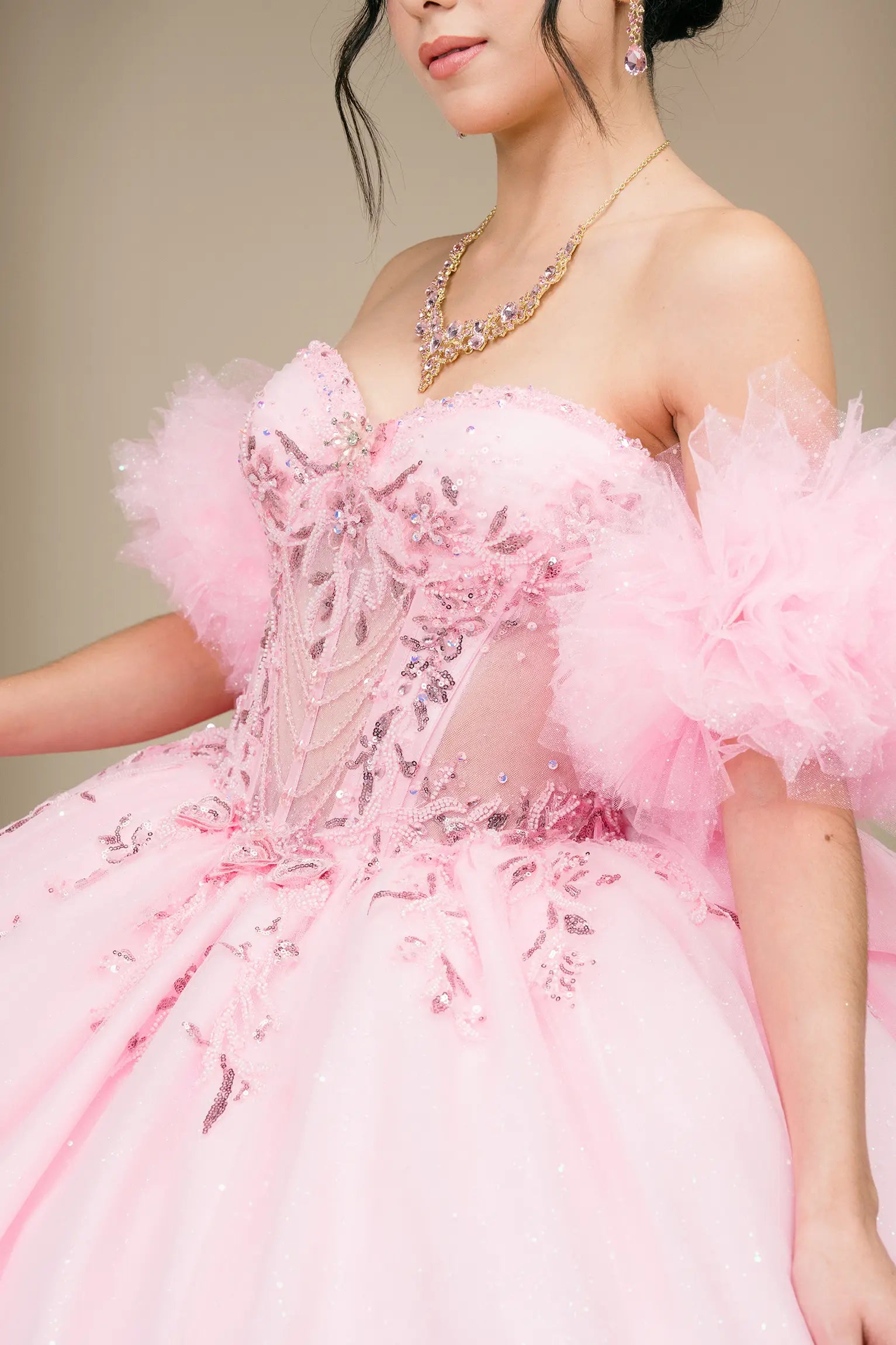 Bodice close-up view:
Close-up of pink quinceañera dress bodice showing sheer corset, intricate beadwork, sequins, and off-shoulder tulle sleeves.