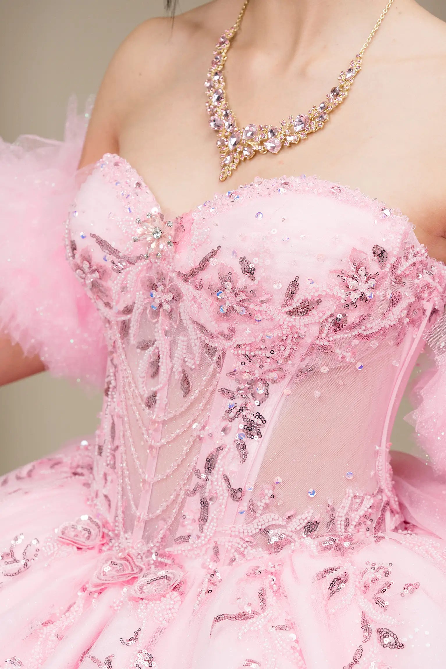 Bust detail view:
Detailed view of the sweetheart neckline and embellished corset bodice with pink embroidery, sequins, and layered tulle.