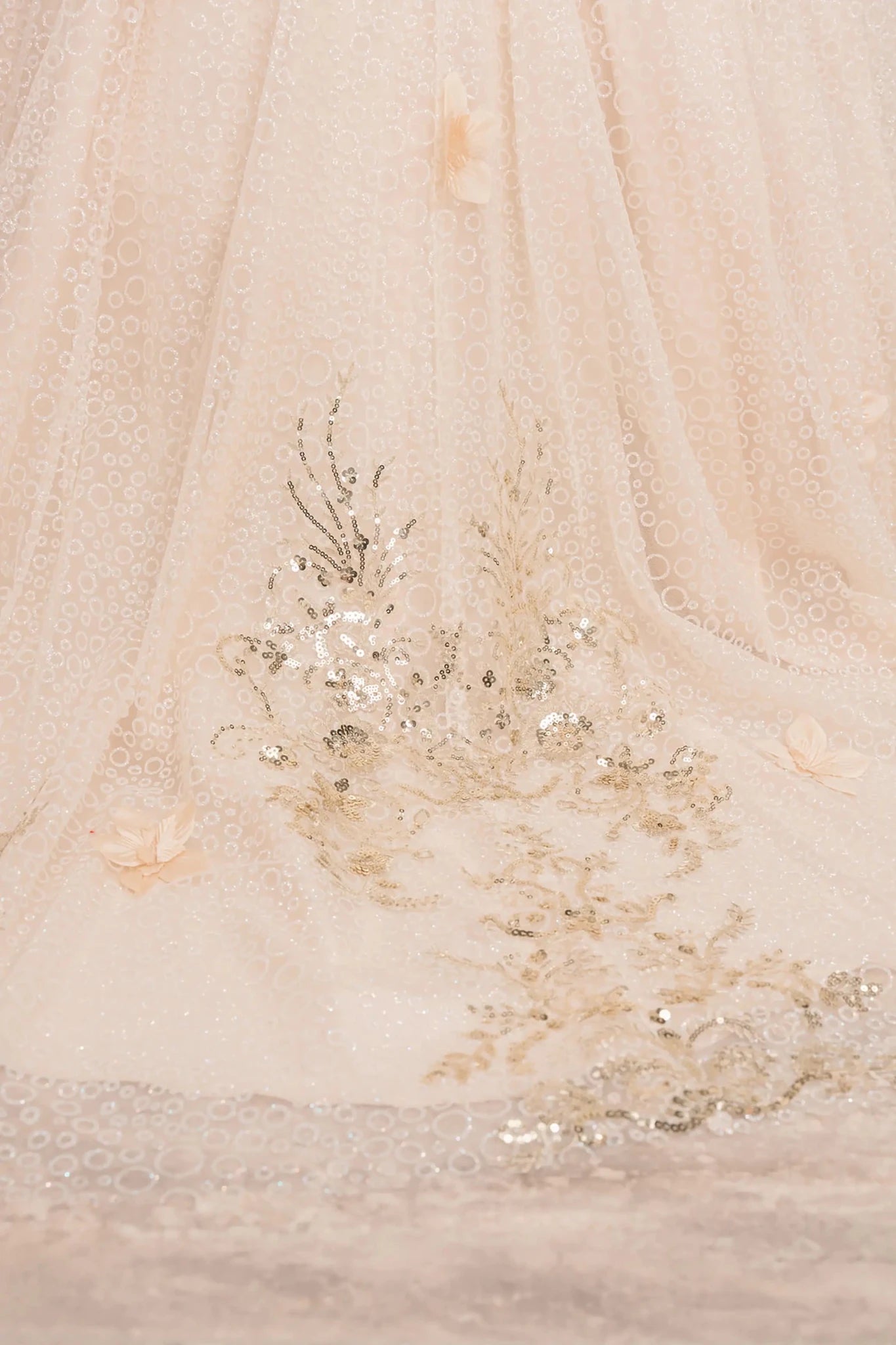 Close up view of Champagne mini quince mini quince dress with glitter floral embroidered bodice skirt.